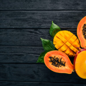 Mango and Papaya. Tropical Fruits. On a wooden background. Top view. Copy space.